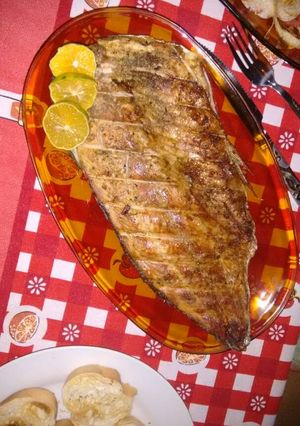 Una foto de Sábalo a la parrilla; ensalada de tomates, queso y cebolla asada