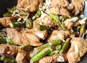 Une photo de Wok poulet, asperges vertes et amandes grillées