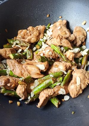 Une photo de Wok poulet, asperges vertes et amandes grillées