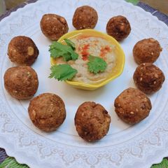 A picture of Falafel balls with hummus.