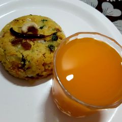 A picture of Rawa upma and orange juice.