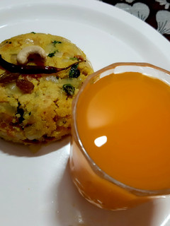 A picture of Rawa upma and orange juice.