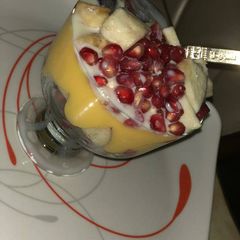 A picture of Custard smoothy garnished with Apple&grapes.