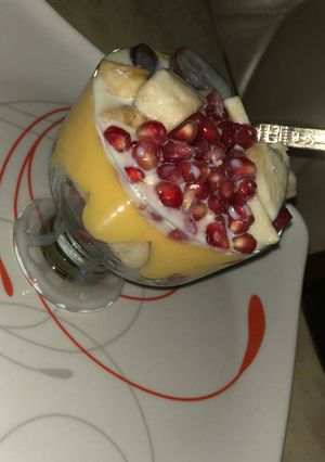 A picture of Custard smoothy garnished with Apple&grapes.