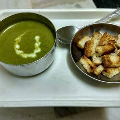 A picture of Palak (spinach) soup with croutons.
