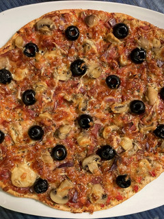 Una foto de Pizza de jamón serrano con aceitunas negras