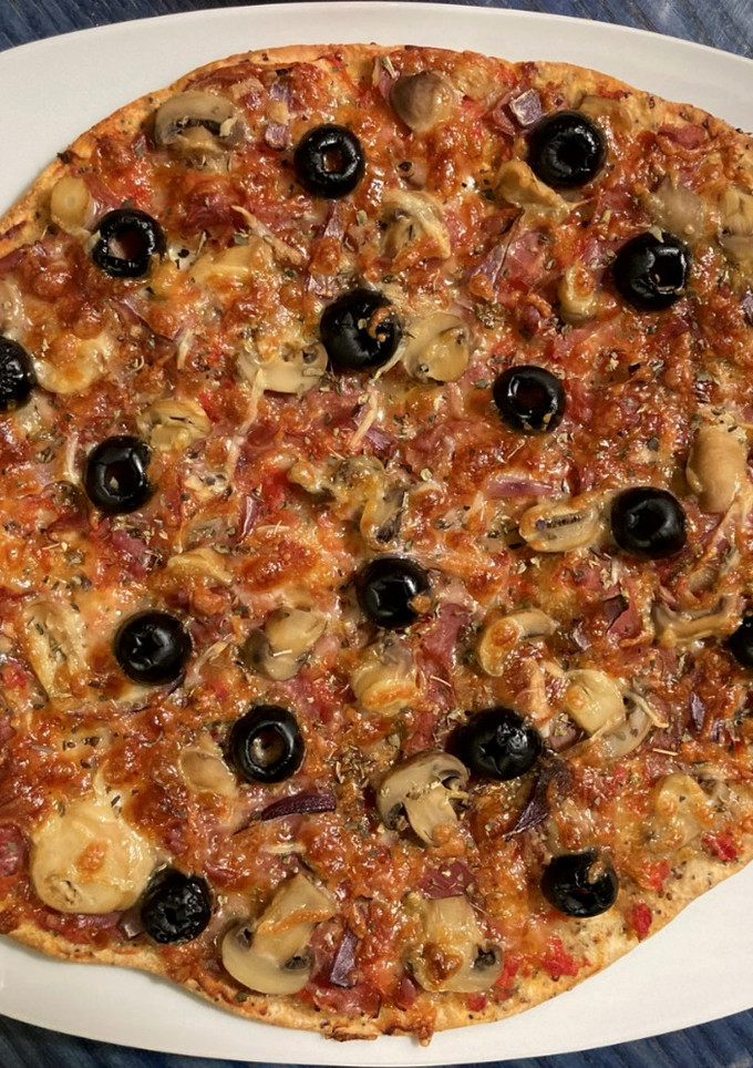 Una foto de Pizza de jamón serrano con aceitunas negras