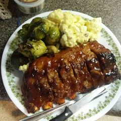 A picture of BBQ pork ribs and no potato, potato salad, Brussel spouts.