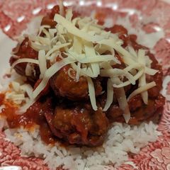 A picture of Beef meatballs in tomato sauce and rice.
