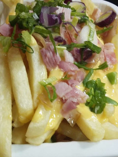 Una foto de Papas Pragas con Cebolla de Verdeo, Panceta y Queso Cheddar