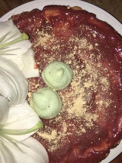 Una foto de Tarta de queso con coulis de fresa decorado con besos de merengue