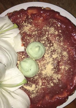 Una foto de Tarta de queso con coulis de fresa decorado con besos de merengue