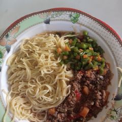 A picture of Spaghetti and minced meat with French beans.
