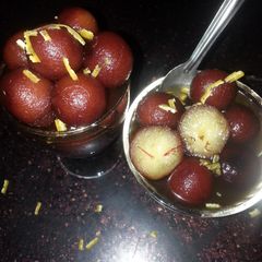 A picture of Spongy Gulab jamuns in saffron n orange zest sugar syrup....