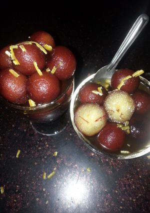 A picture of Spongy Gulab jamuns in saffron n orange zest sugar syrup....