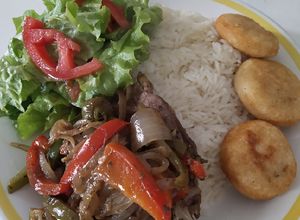 Una foto de Carne con vegetales, arroz, ensalada y arepitas fritas