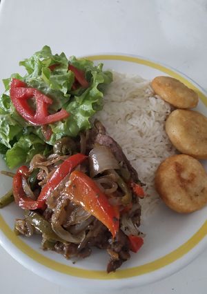 Una foto de Carne con vegetales, arroz, ensalada y arepitas fritas
