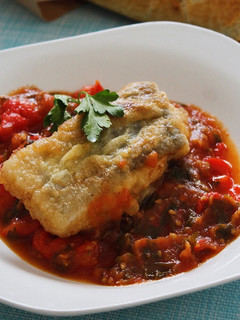 Una foto de Bacalao rebozado con pimientos y tomate