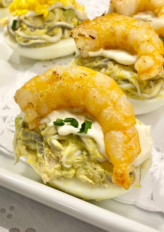 Una foto de Huevos rellenos con gula, aguacate y langostinos