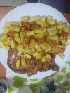 Una foto de Chuletas de cerdo al salmorejo con papas fritas