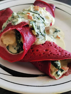 Una foto de Panqueques de betarraga rellenos de pollo en crema con espinaca