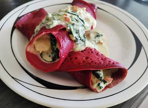 Una foto de Panqueques de betarraga rellenos de pollo en crema con espinaca