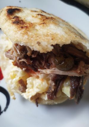 Una foto de Arepa con ensalada de gallina y pernil