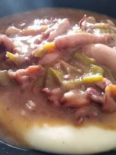 Una foto de Chipirones al vino tinto sobre cama de puré de patatas
