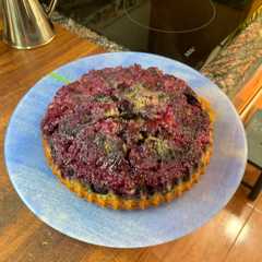 Una foto de Tarta de arándanos invertida con nueces partidas y bizcocho del yogur
