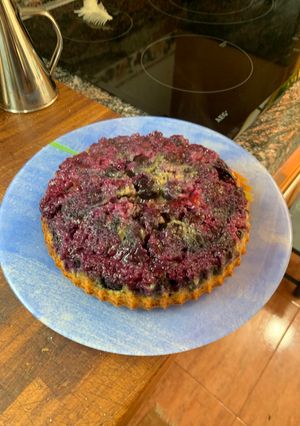 Una foto de Tarta de arándanos invertida con nueces partidas y bizcocho del yogur