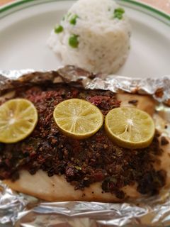 Una foto de Filete de pescado con pasta de aceitunas, tomate y alcaparras
