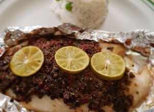 Una foto de Filete de pescado con pasta de aceitunas, tomate y alcaparras