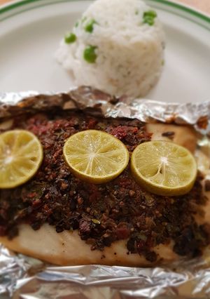 Una foto de Filete de pescado con pasta de aceitunas, tomate y alcaparras