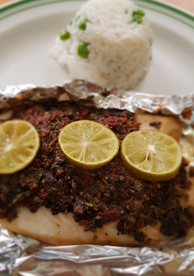 Una foto de Filete de pescado con pasta de aceitunas, tomate y alcaparras