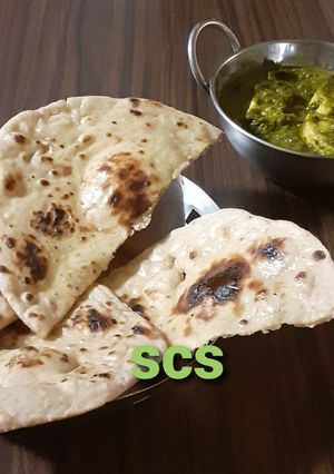 A picture of Whole wheat naan on tawa (with yeast).