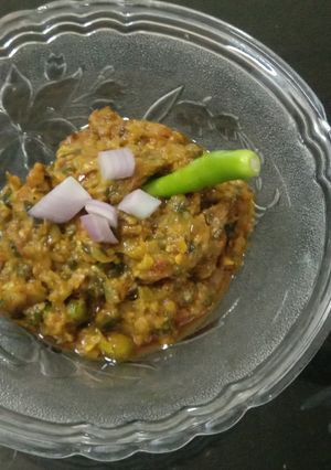 A picture of Baingan bharta with Mutter and green garlic onion.