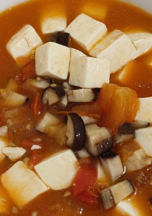 A picture of Tomato mushroom tofu soup.