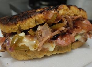 Una foto de Sándwich🥙de carne🥩bbq🍯, cebolla🧅, pimiento🫑y queso🧀
