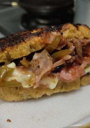 Una foto de Sándwich🥙de carne🥩bbq🍯, cebolla🧅, pimiento🫑y queso🧀