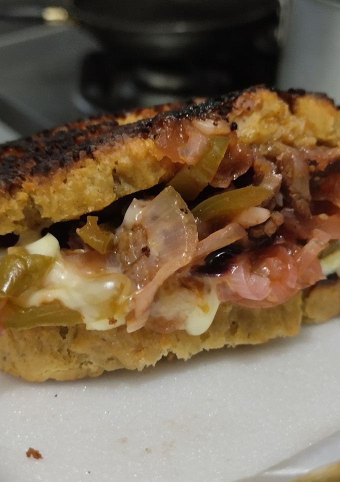 Una foto de Sándwich🥙de carne🥩bbq🍯, cebolla🧅, pimiento🫑y queso🧀