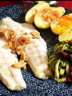 Una foto de Lubina, patatas y tallarines de calabacín con tomate seco, orégano y albahaca 🌿