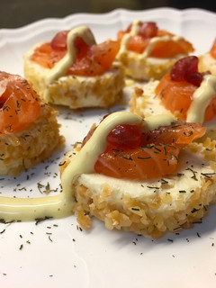 Una foto de Canapés de queso con piña, salmón y granada