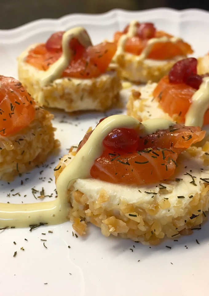 Una foto de Canapés de queso con piña, salmón y granada