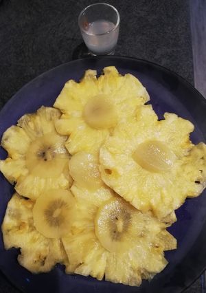 Une photo de Carpaccio d'ananas et kiwi jaune accompagné de son sirop