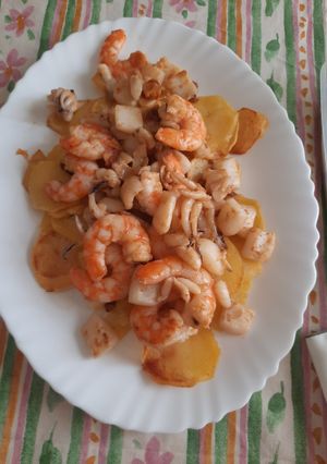 Una foto de Patatas arrieras con sepia y langostinos