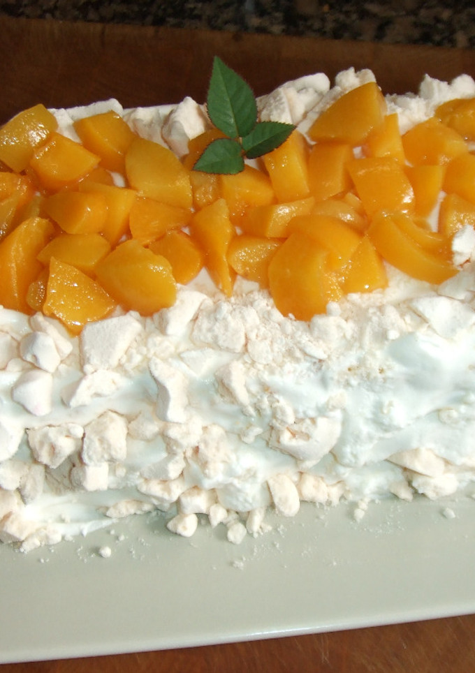 Una foto de Postre chajá de Paysandú, bizcocho  con merengues, dulce de leche y melocotones