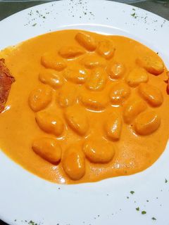 Una foto de Ñoquis con salsa de piquillos y queso de cabra