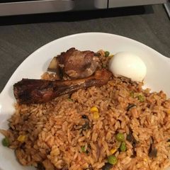 A picture of Jollof rice with chicken and egg.