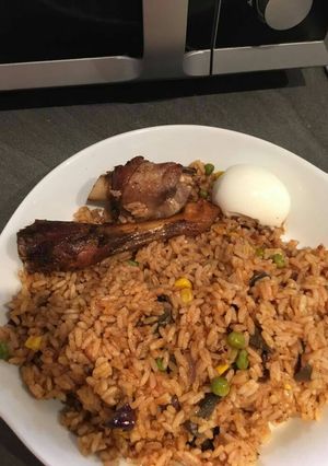 A picture of Jollof rice with chicken and egg.