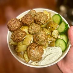 A picture of Greek turkey meatballs over lemon dill potatoes.